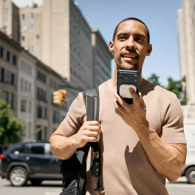 Man speaking into an iPhone with a white SpeakON device attached