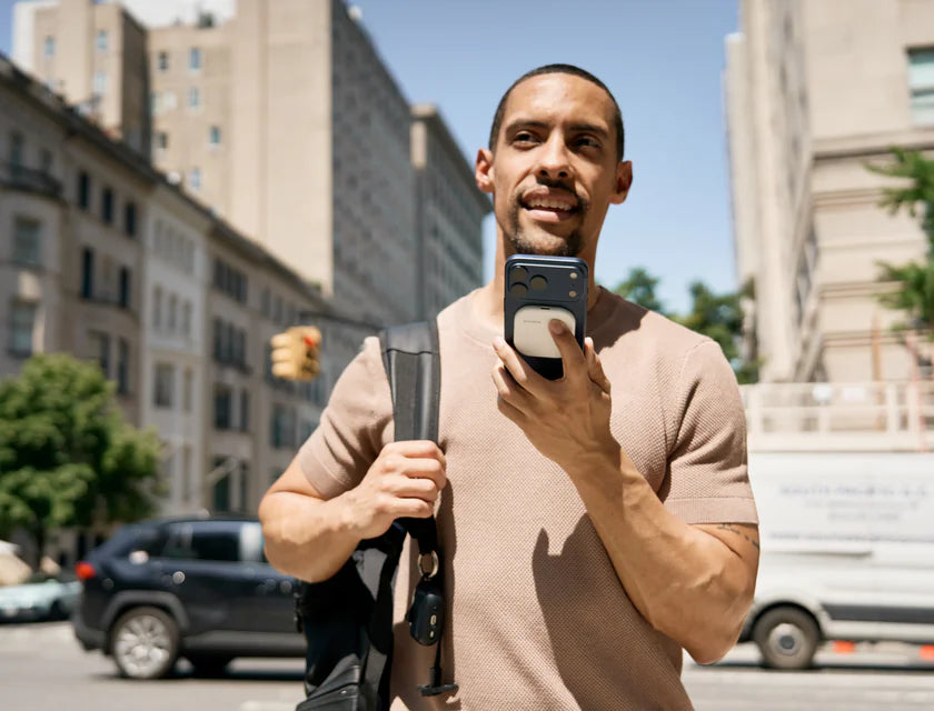 Man speaking into an iPhone with a white SpeakON device attached