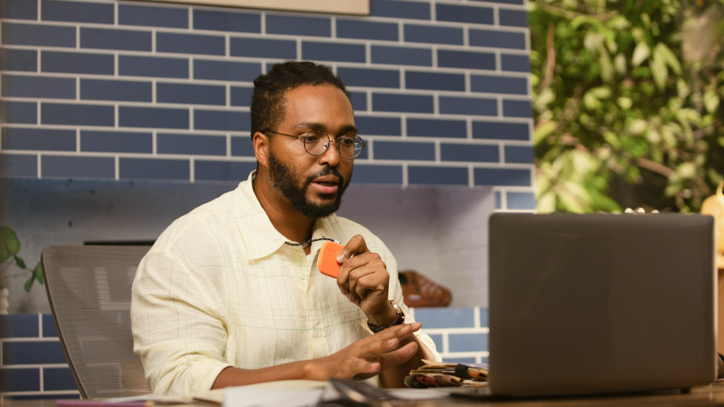 A man dictates a reply with an orange SpeakON device.